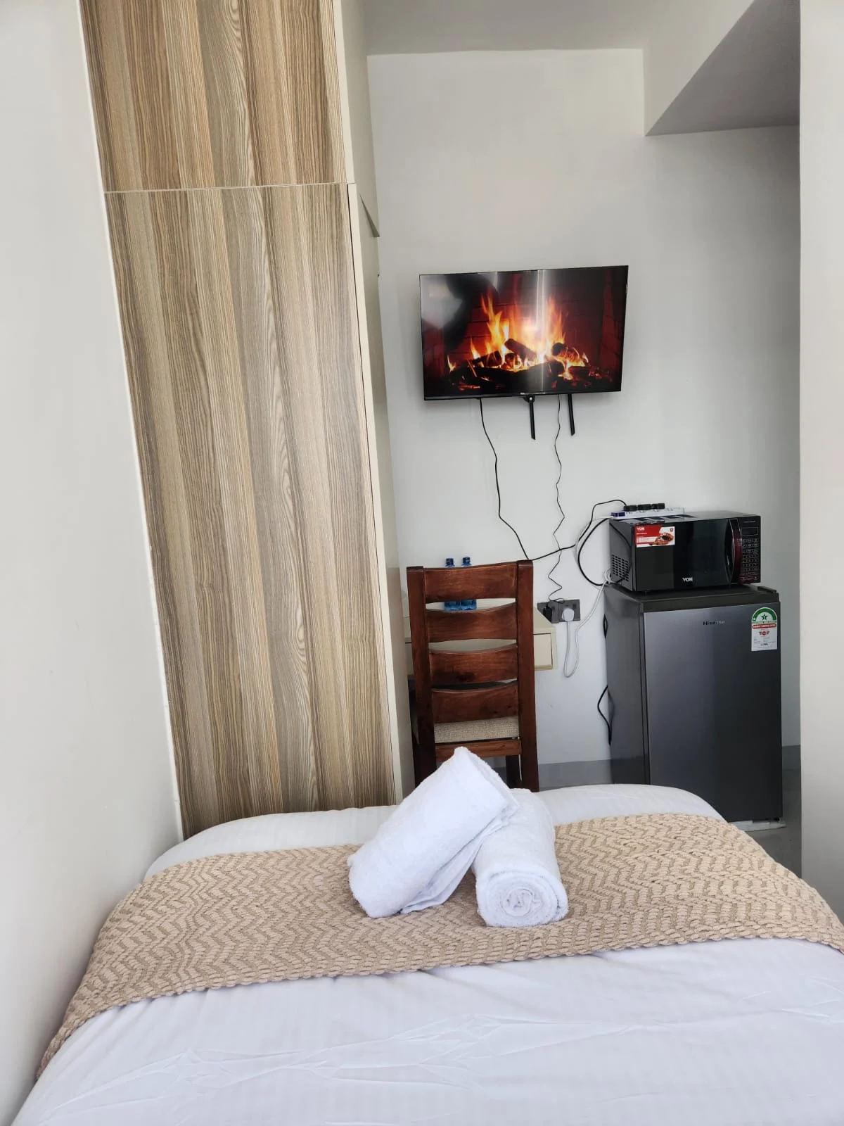The studio, with the bed, smart TV, mini fridge and microwave
